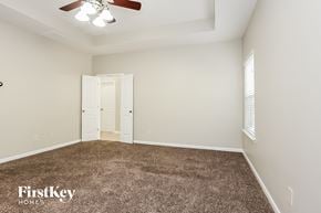 Woodstock house for rent - a bedroom with a carpeted floor and a ceiling fan