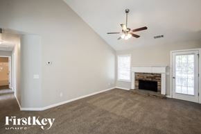Jefferson house for rent - A spacious room with a fireplace and a ceiling fan.