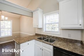 Jefferson house for rent - A kitchen with granite countertops and white cabinets.