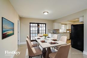 Cape Coral house for rent - A dining room with a table set for six and a painting on the wall.