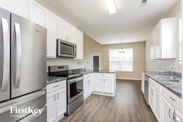 Wake Forest house for rent - a kitchen with stainless steel appliances and white cabinets