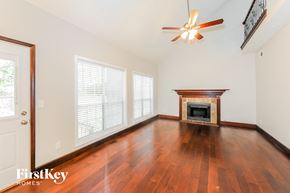 Woodstock house for rent - an empty living room with wood floors and a fireplace