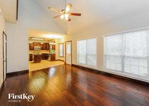 Woodstock house for rent - an empty living room with wood floors and a ceiling fan
