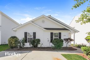 Charlotte house for rent - a white house with black shutters and a sidewalk in front of it