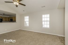 Charlotte house for rent - an empty living room with a ceiling fan and a window