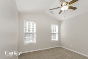 Charlotte house for rent - a bedroom with a ceiling fan and two windows
