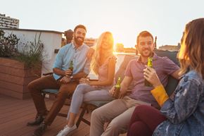 Washington apartment for rent - a group of people sitting on a roof terrace holding beers