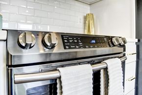 Washington apartment for rent - a kitchen with a stainless steel stove and oven with towels hanging on it