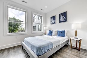 Washington apartment for rent - a bedroom with a bed and three windows