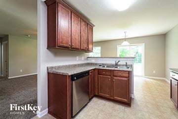 Kernersville house for rent - A kitchen with wooden cabinets and a granite countertop.