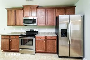 Kernersville house for rent - A kitchen with wooden cabinets and a stainless steel refrigerator.