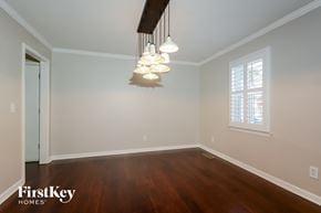 St Louis house for rent - a dining room with a wood floor and white walls and a chandelier