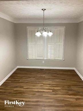 Woodstock house for rent - a empty living room with wood floors and a chandelier