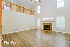 Canal Winchester house for rent - A spacious living room with a fireplace and wooden flooring.