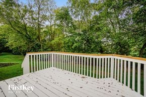 Canal Winchester house for rent - A wooden deck with a railing and trees in the background.