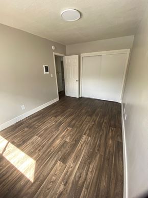 Vista apartment for rent - a living room with wood flooring and a door into a bedroom