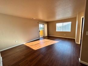 Manteca house for rent - an empty living room with hard wood floors and a window
