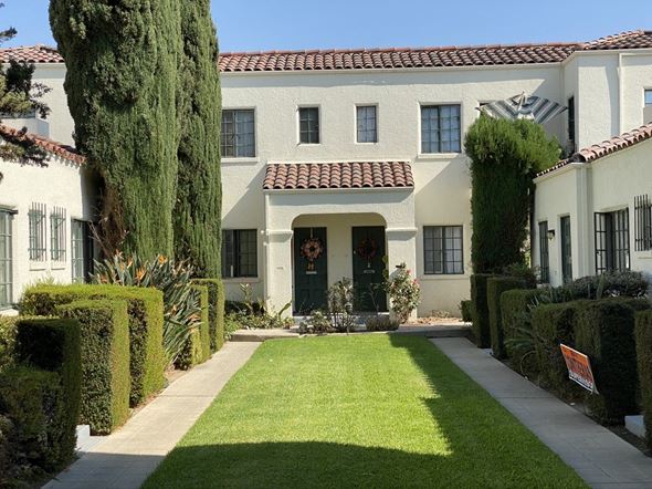 Santa Ana apartment for rent - A white house with a red tile roof and a green door.