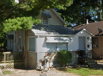 Kalamazoo apartment for rent - A white house with a brown roof and a porch.