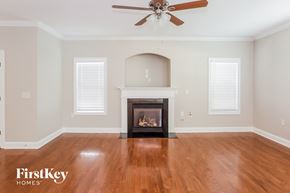 Cornelius house for rent - A living room with a fireplace and a ceiling fan.