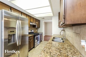 Houston house for rent - a kitchen with stainless steel appliances and granite counter tops