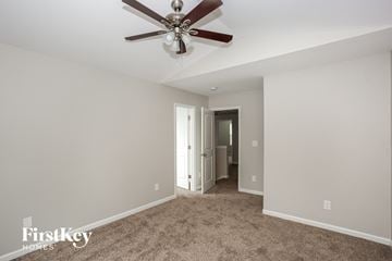 Charlotte house for rent - a living room with carpet and a ceiling fan