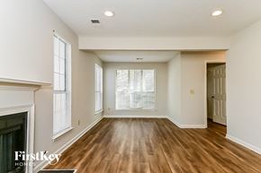Rex house for rent - an empty living room with a fireplace and wood flooring