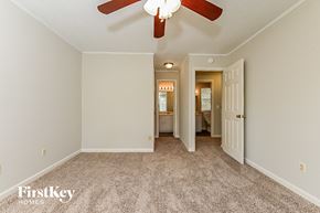 Rex house for rent - a master bedroom with carpet and a ceiling fan