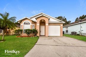 Orlando house for rent - A house with a driveway and a palm tree in front.