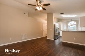 Orlando house for rent - A spacious room with a ceiling fan and wooden flooring.