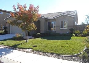 Manteca house for rent - a house with a lawn and a tree in front of it