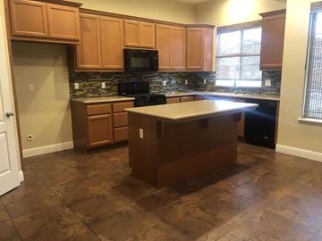 Manteca house for rent - a kitchen with wooden cabinets and a counter top