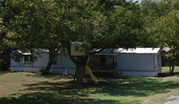 Fort Worth apartment for rent - A tree in a yard with a white house in the background.