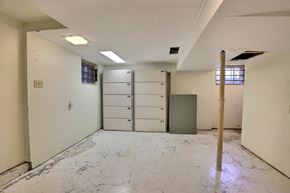 Regina apartment for rent - A room with white walls and a concrete floor with a door and a window.