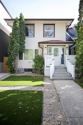 Regina apartment for rent - A white house with a green lawn in front.