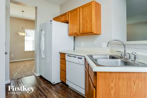 O'fallon house for rent - a kitchen with white appliances and wooden cabinets and a white refrigerator