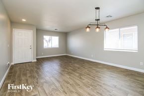Youngtown house for rent - A room with wooden flooring and a chandelier hanging from the ceiling.