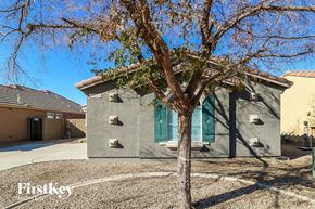 Surprise house for rent - a house with green doors and a tree in front of it
