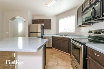 Surprise house for rent - a kitchen with stainless steel appliances and a white counter top