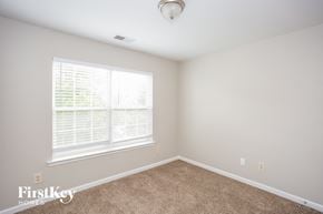 Huntersville house for rent - a bedroom with a carpeted floor and a large window