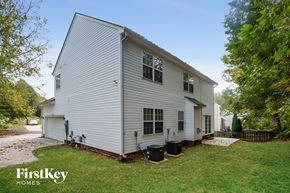 Huntersville house for rent - the back of a white house with a yard and trees