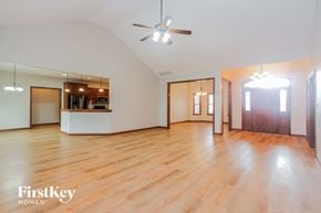 Camby house for rent - an empty living room with wood floors and a ceiling fan