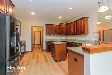 Camby house for rent - a kitchen with wood flooring and stainless steel appliances and wooden cabinets