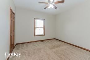 Camby house for rent - a bedroom with a carpeted floor and a ceiling fan
