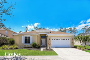 North Port house for rent - a beige house with a white garage door and a lawn