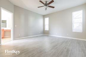 North Port house for rent - an empty living room with a ceiling fan and wood floors