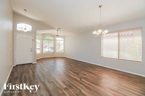 San Tan Valley house for rent - A room with wooden floors and a chandelier hanging from the ceiling.