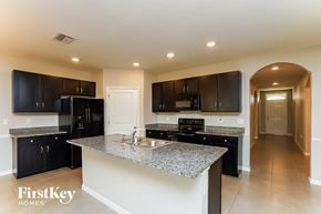 Wesley Chapel house for rent - a kitchen with black cabinets and a granite counter top