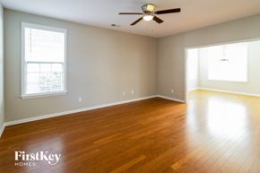 Summerville house for rent - an empty living room with wood floors and a ceiling fan