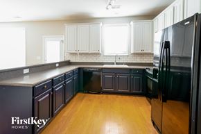 Summerville house for rent - a black and white kitchen with wood floors and white cabinets